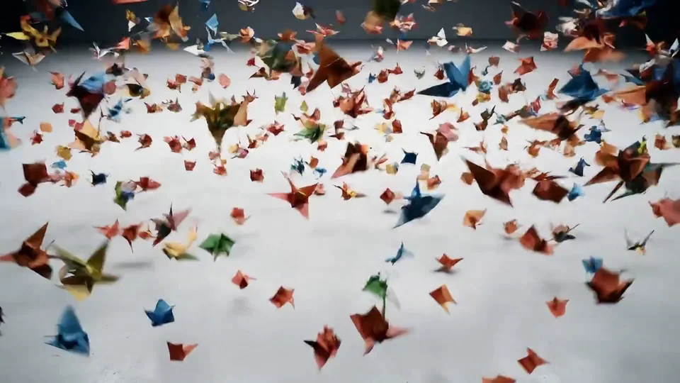 Paper cranes rising into a sphere